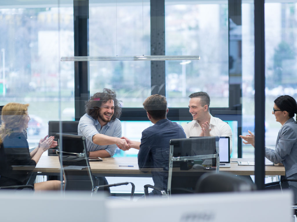 Professionals smiling in after a jo interview and shaking hands